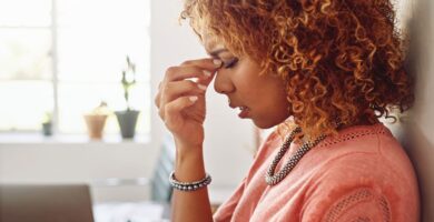 woman suffering from a headache due to low progesterone symptoms