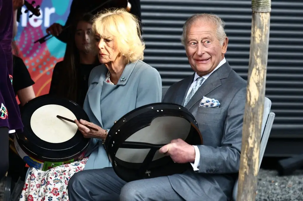 King Charles applauded throughout his shock look 1 Britain's King Charles III and Britain's Queen Camilla play bodhran drums, traditional Irish drums, as they watch dancers perform to mark Fleadh Cheoil na híreann coming to Belfast in August, at Thompson Dock in Belfast, Northern Ireland, May 19, 2026, during their three-day visit to Northern Ireland.