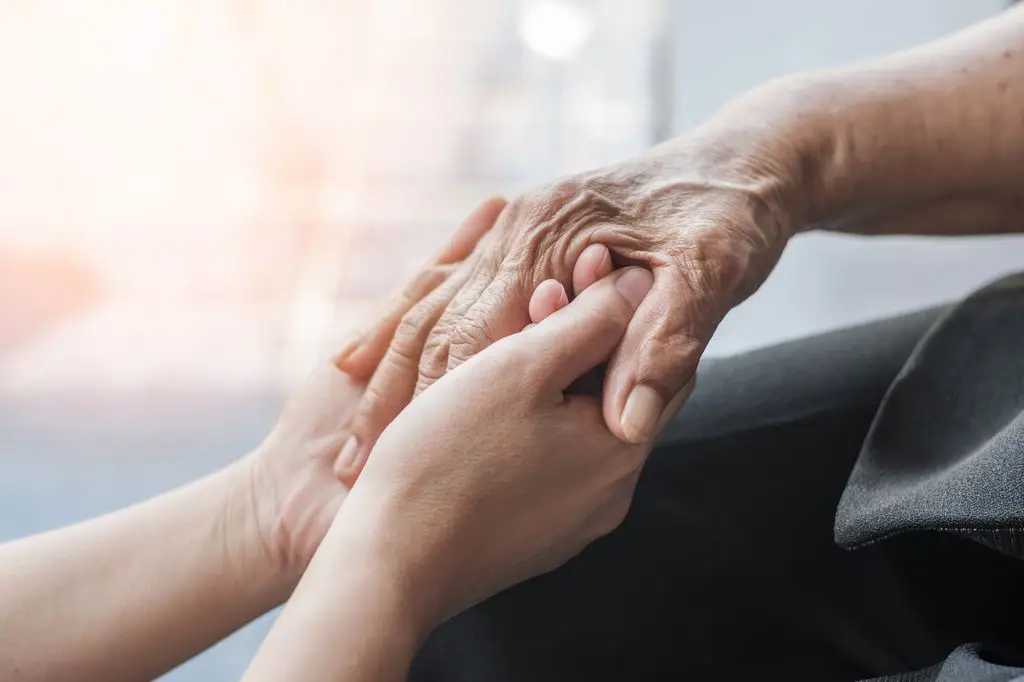 5 each day habits to hurry up your joint ache 2 Two hands, one older and one younger, are held in a comforting gesture.