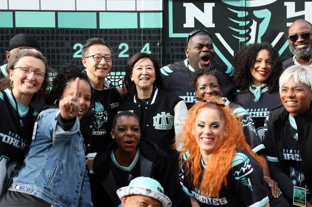 Joe Tsai and Clara Wu Tsai, owners of New York Liberty, pose with dance group Timeless Torches during the New York Liberty Ticker Tape Victory Parade & Rally on October 24, 2024 in New York.