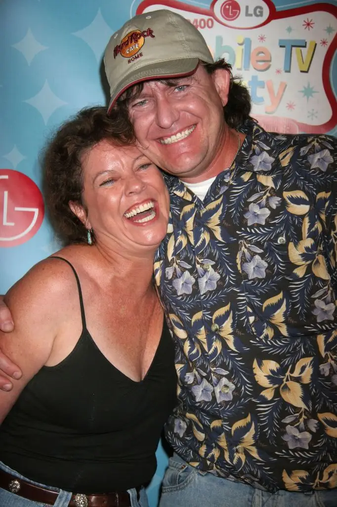 Erin Moran laughs as she leans toward her husband Steven Fleischmann, who smiles and wraps an arm around her back.