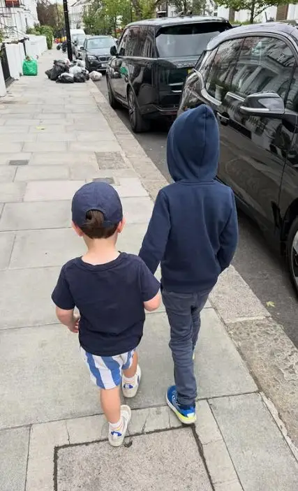 Two young boys walk on a path