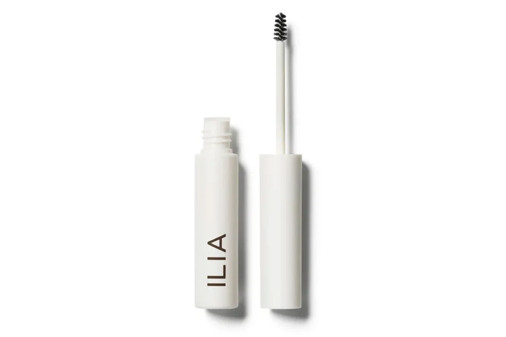 Ilia's Mates & Household Sale Presents Up To 25% Off Superstar-Favourite Magnificence Buys 2 Tube of ILIA brand eyebrow gel with the wand removed, displaying its brush.