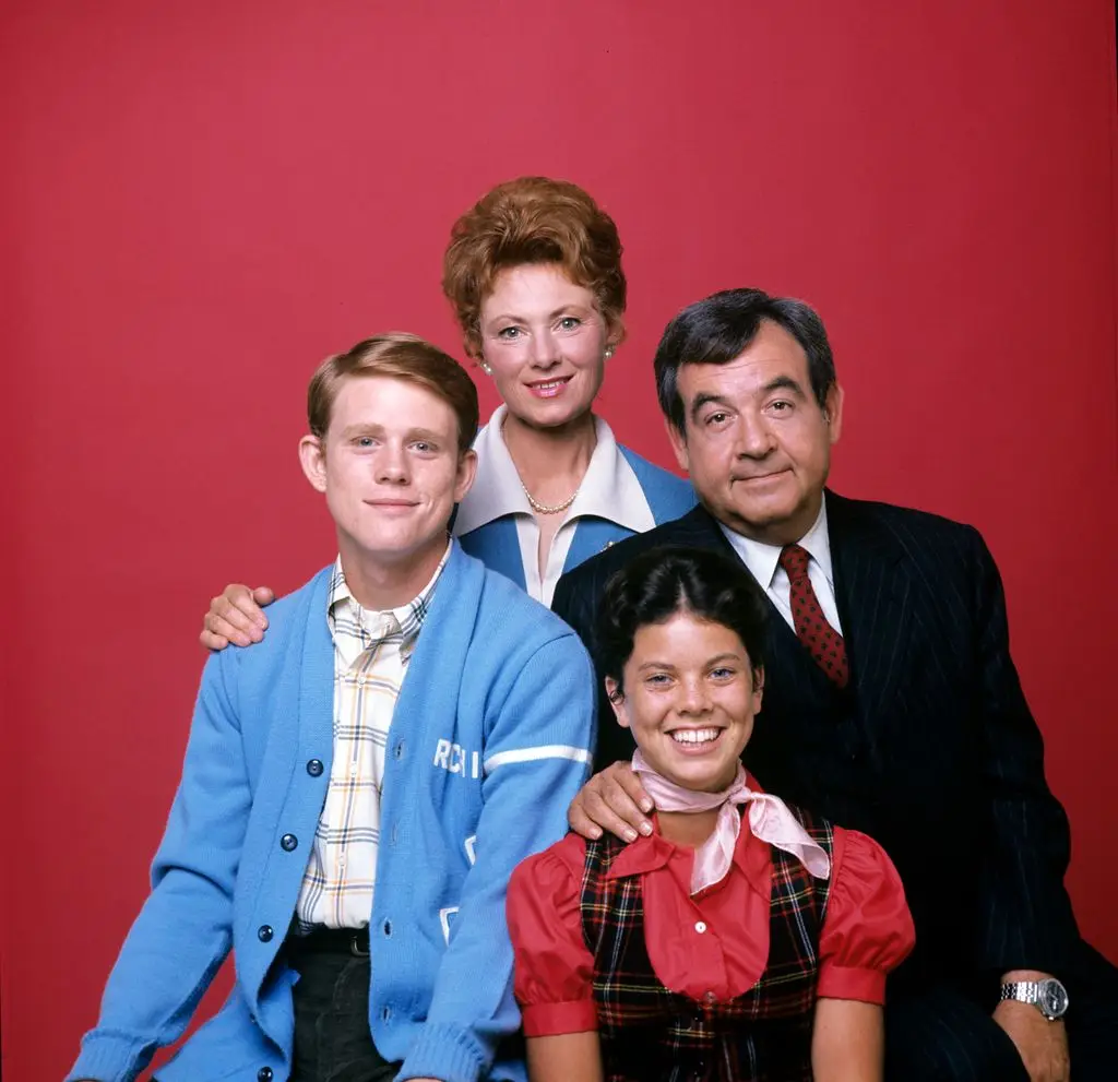 Happy Days' Tom Bosley, Marion Ross, Erin Moran and Ron Howard pose in front of a red background.