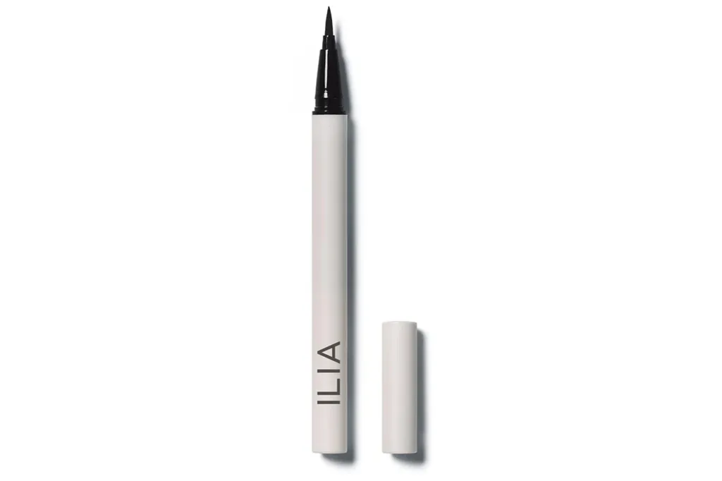 Ilia's Mates & Household Sale Presents Up To 25% Off Superstar-Favourite Magnificence Buys 1 ILIIA liquid eyeliner with the cap removed, revealing the fine tip.