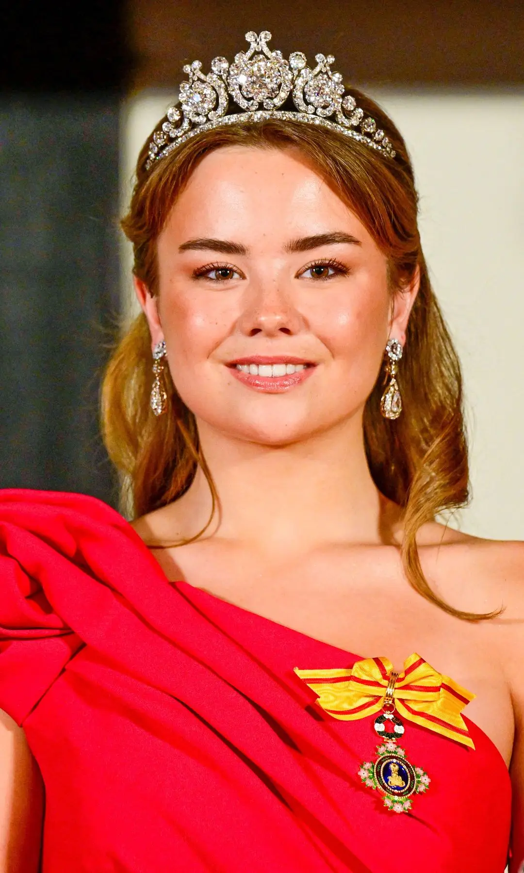 Princess Ariane smiling in a diamond tiara and red dress