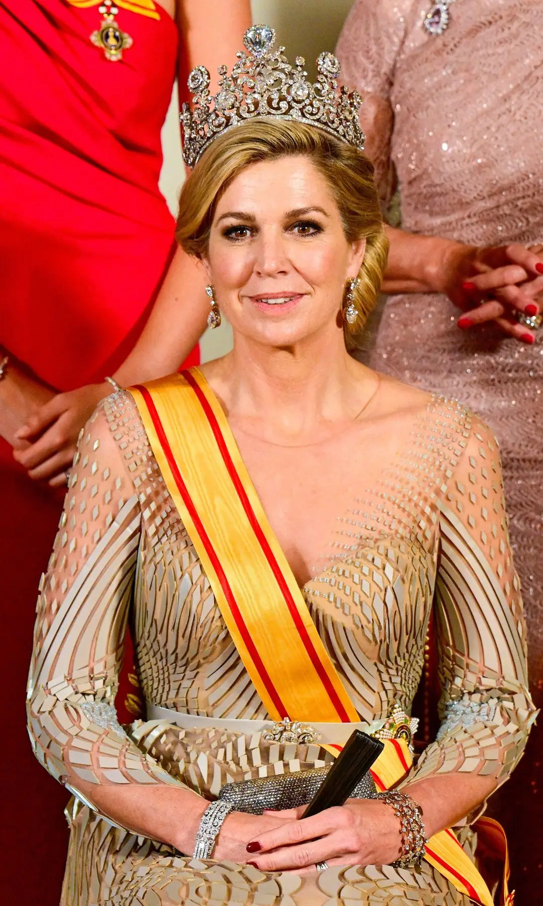 Queen Maxima seated in a golden robe and crown