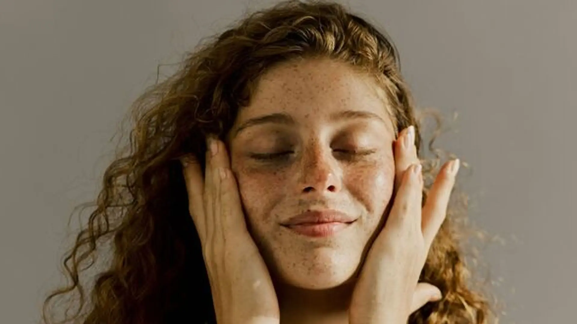 I attempted Japanese double hydration for a month 1 A model with red hair and freckles, eyes closed, holding her face as if she had just applied skincare.