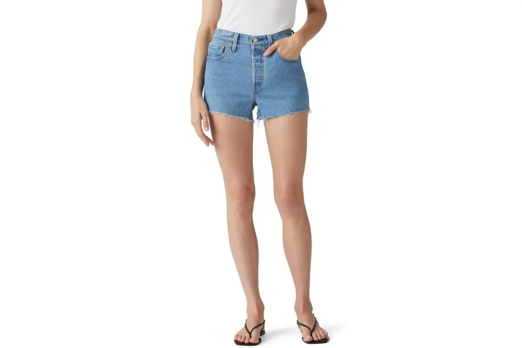 What to Purchase and Keep away from Procuring on Prime Day, In response to Skilled Customers 5 Light wash denim shorts with frayed hems worn by a person wearing a white top and black sandals.