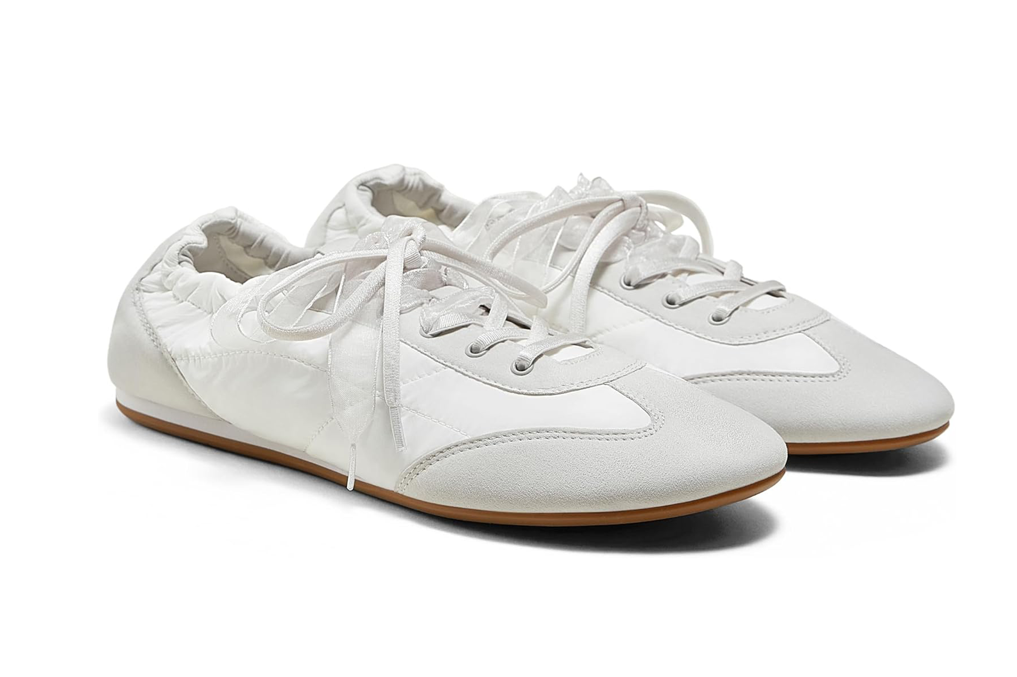 A pair of white sneakers with textured fabric, suede toes and rubber soles.