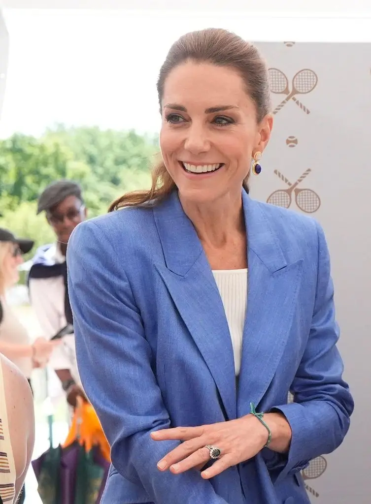 Princess Charlotte's handmade reward for mother Kate Middleton throughout her hardest week 2 A smiling Kate Middleton, dressed in a blue blazer and white top, stands in front of a tennis-themed setting.