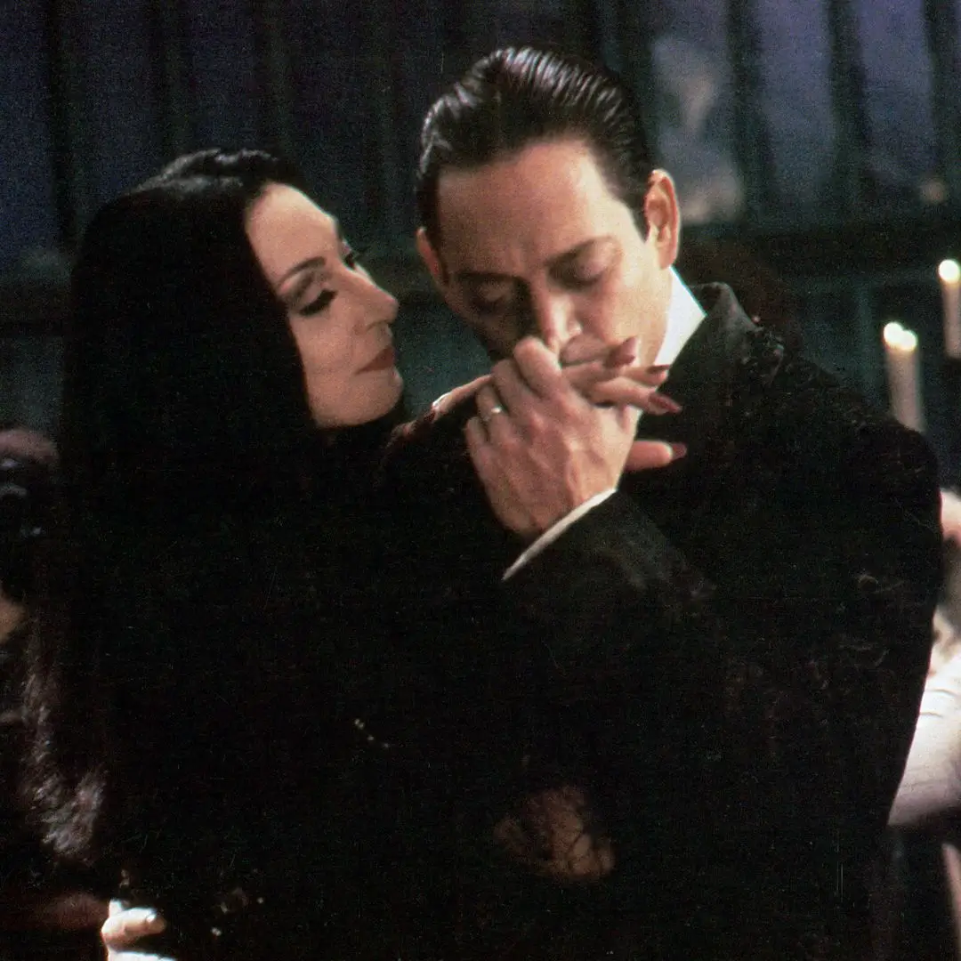 Anjelica Huston is kissed by Raul Julia in a scene from the film 