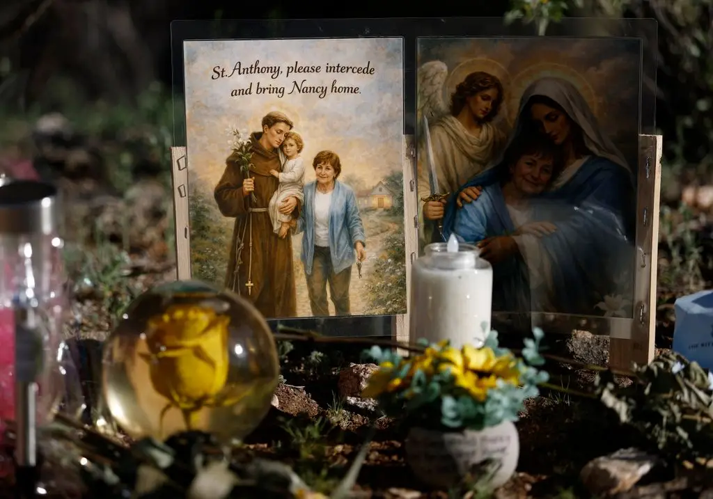 A photo is displayed in front of Nancy Guthrie's house 