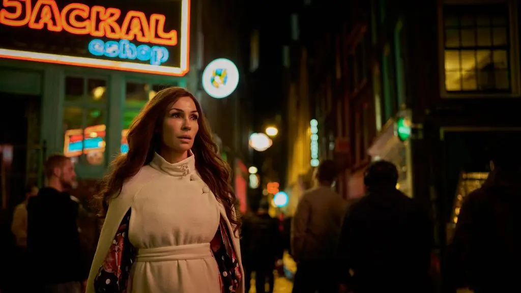 Bond lady Famke Janssen, 61, seems to be a long time youthful in mini costume 4 woman walking down a dimly lit street