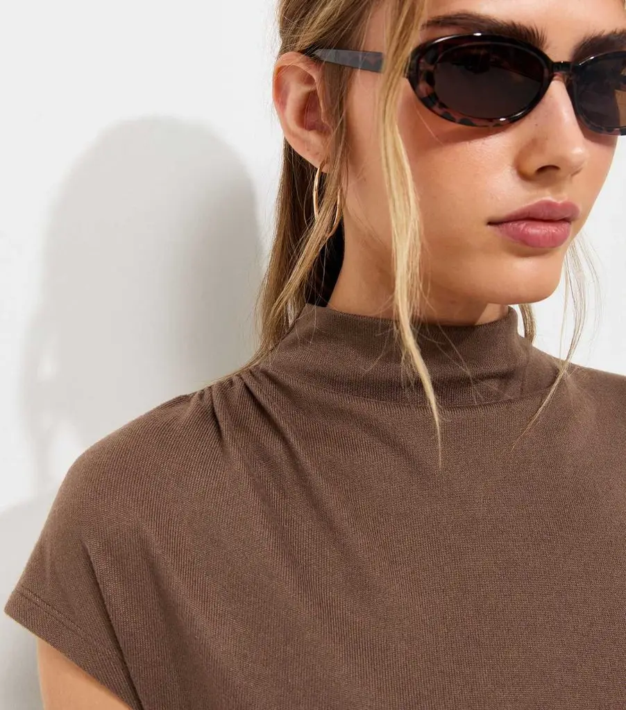 Close-up of model in new brown high-neck top