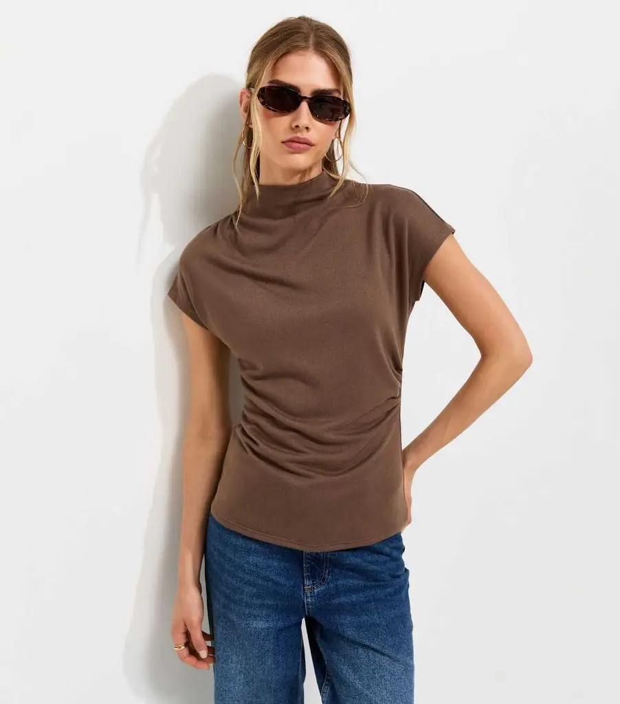 woman in brown new look top with high collar 