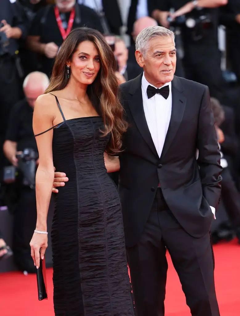 Amal and George Clooney, arms around each other 