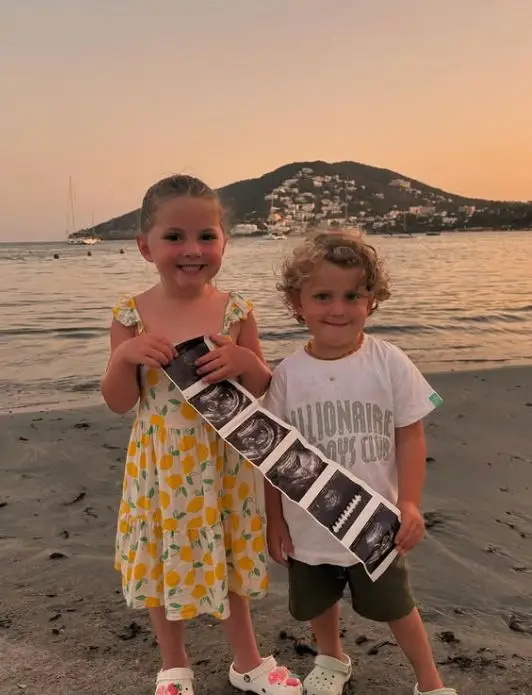 Meet Strictly star Lacey Turner's 3 children she shares along with her husband after tragic miscarriages 3 Two children on a beach holding an ultrasound scan. The girl is wearing a lemon print dress and the boy is wearing a white t-shirt with the text