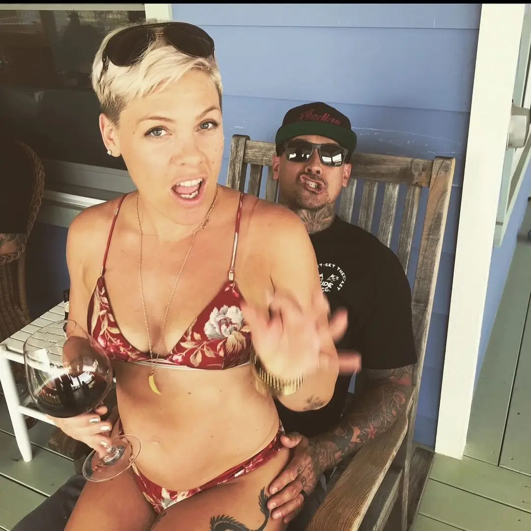 Pink pictured sitting on husband Carey Hart's lap with a glass of wine, shared on Instagram in 2024