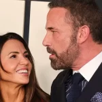 Matt Damon's wife, 50, stands out from the crowd in a bright red suit as she laughs with Ben Affleck