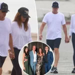 Cindy Crawford and her husband Rande Gerber hold hands during a walk on the beach