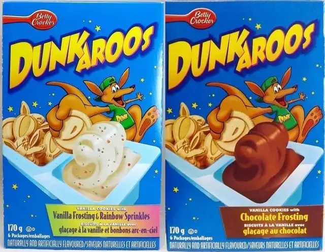 Two blue Dunkaroos snack boxes featuring a cartoon kangaroo, one labeled vanilla frosting with rainbow sprinkles and the other labeled chocolate frosting.