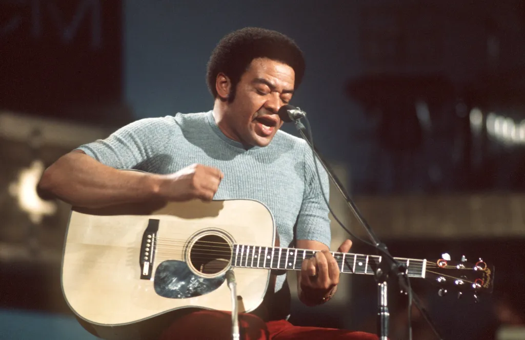 Olivia Dean's tune accused of ripping off the melody from Invoice Withers' "Simply the Two of Us" 1 American singer, guitarist and songwriter Bill Withers performs on stage.