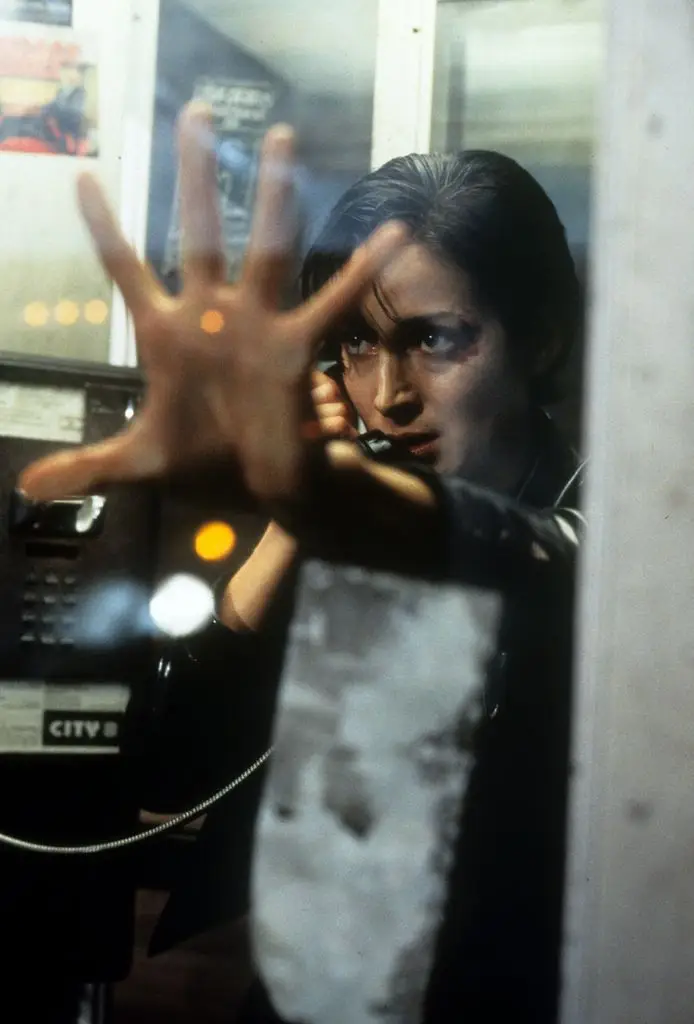 Carrie-Anne Moss in a telephone booth in a scene from The Matrix, 1999.