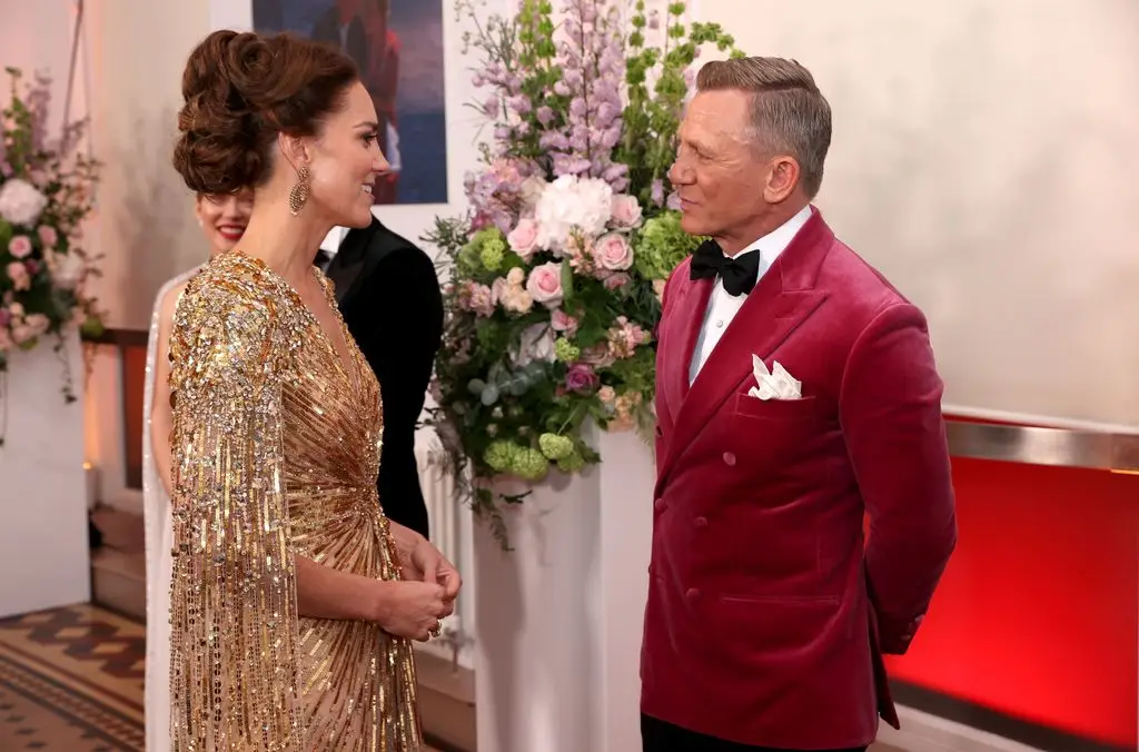 Queen Mathilde reinvents royal black tie in dramatic look liked by Kate Middletob 2 Kate in a gold dress speaking with Daniel Craig