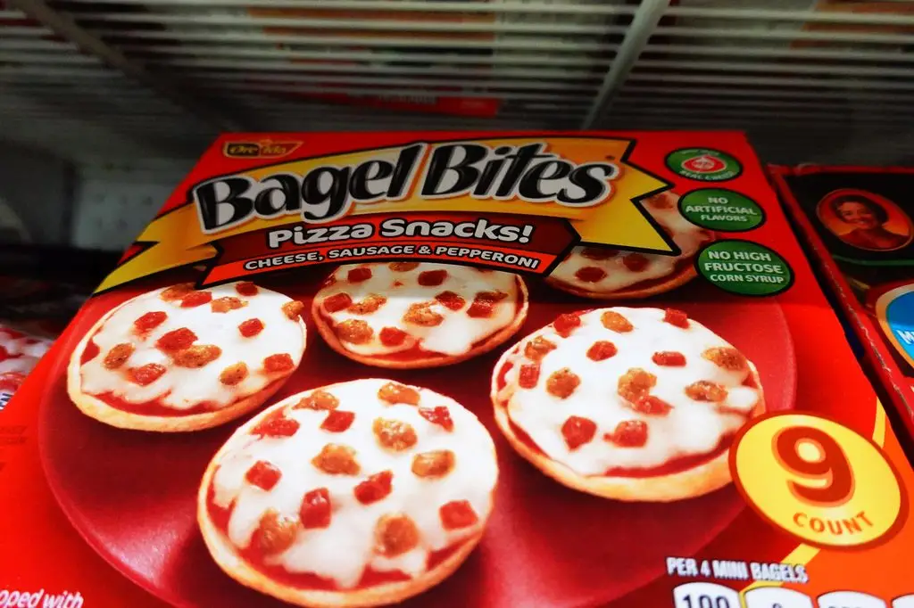A box of Bagel Bites cheese, sausage and pepperoni pizza snacks displayed on a grocery store shelf.